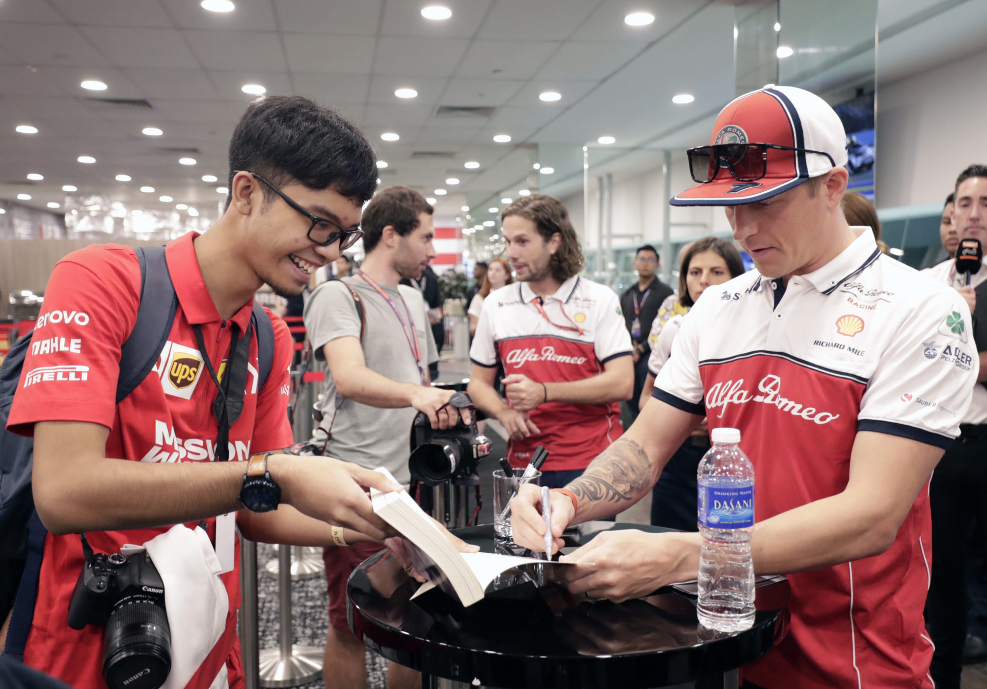 Alfa Romeo driver Kimi Raikkonen signing autographs