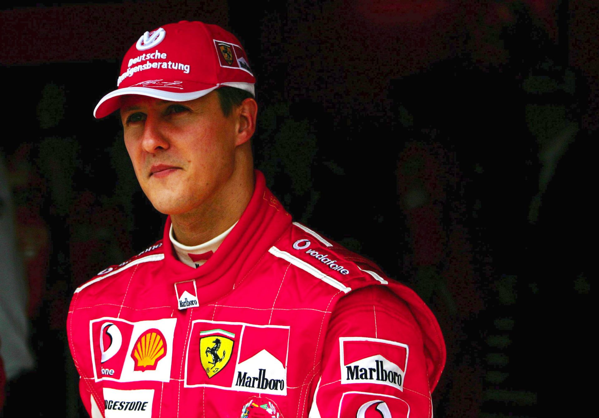 Michael Schumacher looks on in his Ferrari racing suit