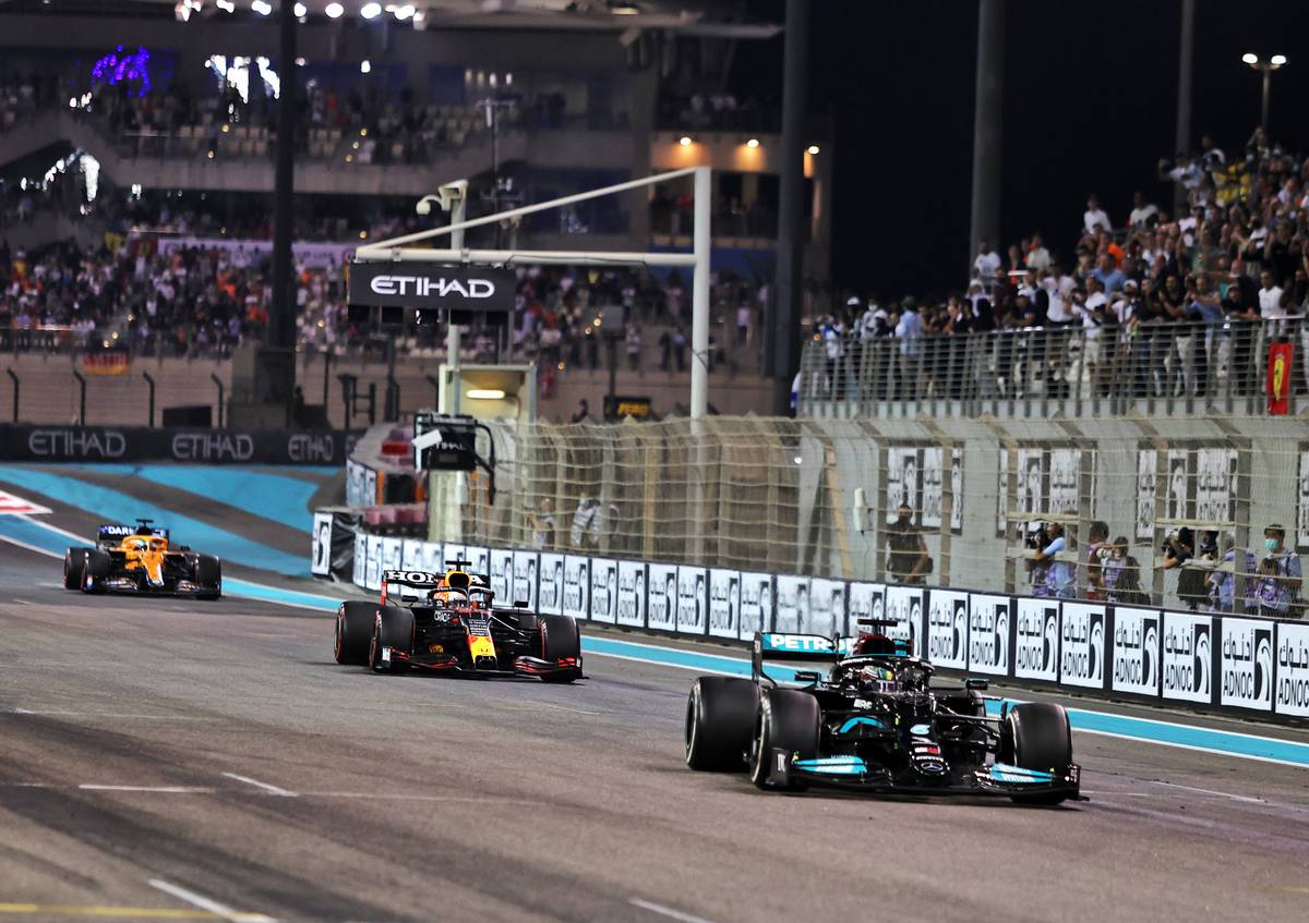 Lewis Hamilton (GBR) Mercedes AMG F1 W12 leads Max Verstappen (NLD) Red Bull Racing RB16B on the final lap of the race. 12.12.2021. Formula 1 World Championship, Rd 22, Abu Dhabi Grand Prix, Yas Marina
